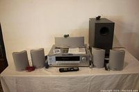 Complete Onkyo 5.1 channel home theater system components arranged on a table including AV receiver, five speakers and subwoofer.