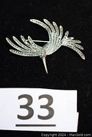 Front angled view of the hummingbird pin showing detailed wing and tail feathers with marcasite stones.