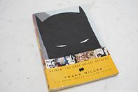 Soft cover graphic novel showing front cover featuring Batman silhouette and title band with author names.