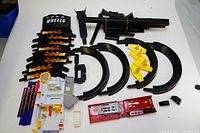 View of multiple black track pieces, white station base, yellow barricades, and red launcher ramp.