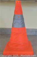 Expanded orange canvas portable pylon with a reflective gray stripe visible in upright position.