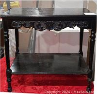 Full view of the ebony black antique hand carved occasional table showing front and leg details.