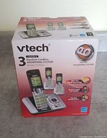 Front of the original Vtech cordless phone box displaying 3 handset cordless answering system with caller ID and call waiting, image of handsets and base, Vtech branding.