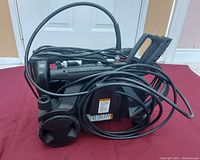 Side view of black Pro Point power washer with coiled hose and power cord.