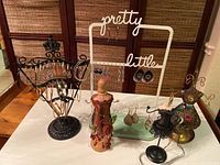 Overall display of five jewelry holders with assorted costume earrings including segmented loops, metal designs, and colorful feather style earrings