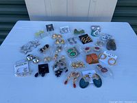 Full overview of all assorted pierced earrings displayed on table