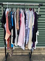 Photo of 16 ladies tops on hangers displaying colors, sleeve lengths and patterns.