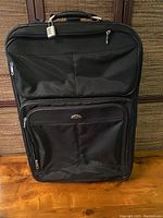 Front view of large black Samsonite luggage with suitcase handle and front pocket