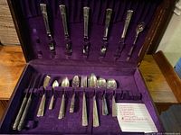 Full set displayed in a wooden velvet-lined chest showing 36-piece Nobility Plate Caprice Art Deco silverware with variety of forks, spoons, knives and other utensils.