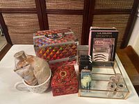 Holographic vanity makeup case and assorted cosmetic and skincare items including pink glass organizer, red bead box, body lotion, and makeup kits on table