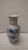 Front view of the blue and white porcelain vase showing the floral and abstract motifs and the overall shape.