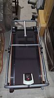 Top-down view of the manual walk folding treadmill showing black walking belt, metal frame, and digital display unit at front center.