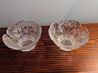 Pair of clear crystal glass bowls/votive holders with detailed Cow Parsley flower pattern and scalloped edge, placed on wooden surface.