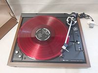 Top view of turntable with red translucent record on platter