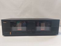 Front view of the Sansui B-1000 amplifier showing dual analog VU meters, power switch and branding.