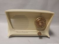 Front and side view of vintage Rogers Majestic tube radio showing cream plastic body and tuning dial.