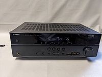 Front view of Yamaha HTR-3063 AV Receiver on a white surface showing power button, headphone jack, input buttons, and volume dial, digital display reads "Decoder Off".