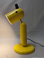 Yellow dog-shaped lamp unlit, showing the shape and design features with ears, nose, and eye details.