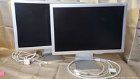 Two Apple Cinema Display monitors shown side by side with cables