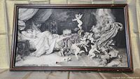 Full view of the Dreams of Love black and white print featuring a sleeping woman and cherubs, framed with visible scratches and worn signature.