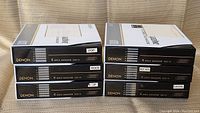 Stack of six Denon 6 Disc Cartridges showing the front labels, each labeled with a different music genre or category