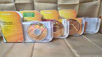 Four Microsoft Office Home and Student 2007 retail packages displayed with three open showing installation discs and one with missing disc.