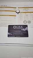 GRA Moissanite certificate laid flat with ring at center
