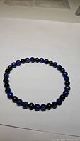 Full view of the stretchy bracelet showing lapis lazuli and black onyx beads on a white background.