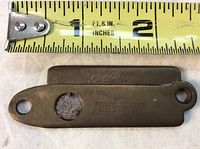 Top side of cigarette cutting tool next to ruler showing 2.5 inch length with Chevrolet branding and engraved text