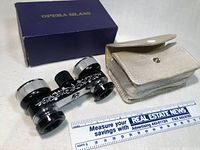 Vintage Strand Baker opera glasses with black and silver finish, decorative scroll pattern, with focusing wheel.