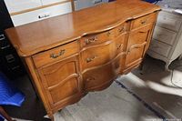 Front full view of the wooden serpentine credenza
