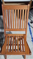 Top-down view of folding teak chair showing slatted seat and backrest