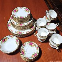 Three stacks of dinner, salad and bread plates with floral and gold pattern