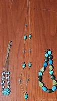 Lot display showing all three necklaces with turquoise stones: gold-tone chain with small stones, multicolor bead necklace, and silver-tone chain with turquoise cluster pendant.