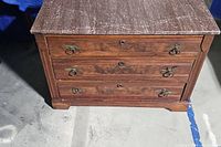 Front view of the wooden three drawer cabinet showing drawer handles and wood finish.