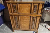 Front view of the six drawer dresser showing the carved wooden decorative panels and metal pulls on drawers.