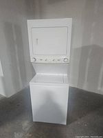Full front view of white stacked washer and dryer