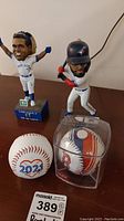 Photo showing the two Blue Jays bobbleheads, the 2021 Blue Jays ball, Boston Red Sox ball, and signed baseball by Devon White.