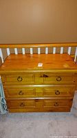 Front view of pine dresser showing three drawers with round metal ring pulls and wood finish.