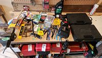 Full view of workbench with all tools and items described, showing clamps, drill, cases, levels, tape, brushes, and vice from above