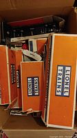 Box with multiple orange and white Lionel Trains boxes stacked inside a larger box