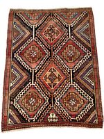 Full view of Shiraz nomadic rug showing geometric diamond pattern in earth tones with red, brown, blue, and cream colors