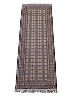 Full view of rectangular Turkmen rug with repeated geometric patterns and fringed ends.