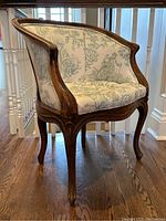 Front right three-quarter view showing carved walnut frame, arms and upholstery pattern