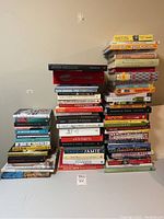 Three stacks of cookbooks on a table against a wall