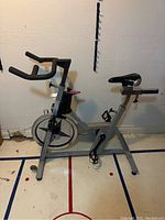 Left-side profile view of Schwinn stationary bike showing frame structure, handlebars and flywheel