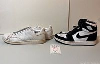 Side view showing both Adidas Stan Smith and Nike Air Jordan 1 sneakers side by side