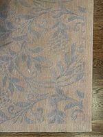 Close-up of raised light blue floral vine pattern on light beige ground