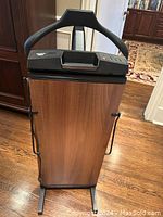 Front view showing walnut-effect front panel, metal feet and side frame