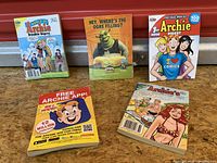 Photo showing 4 Archie Comics digest-sized comic books with colorful covers and one promotional insert.